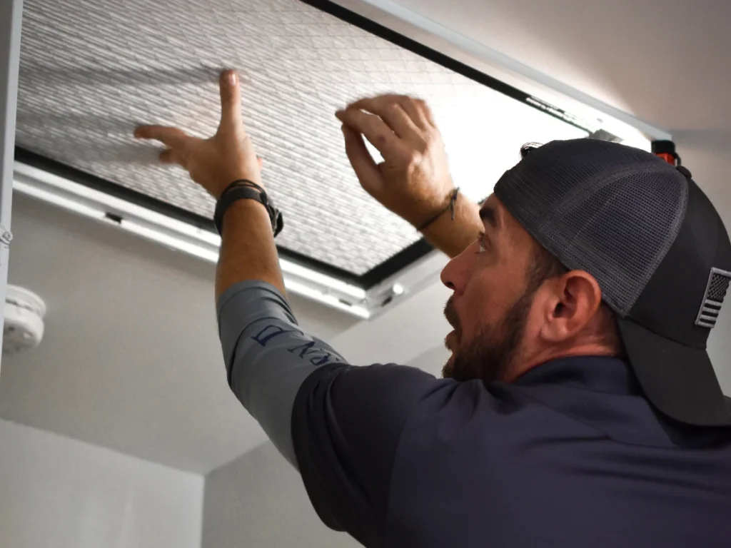 An Annette Hale technician replacing an AC filter during AC maintenance.